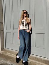 a lady wears a black and white stiped vest with high waisted and loose fit jeans